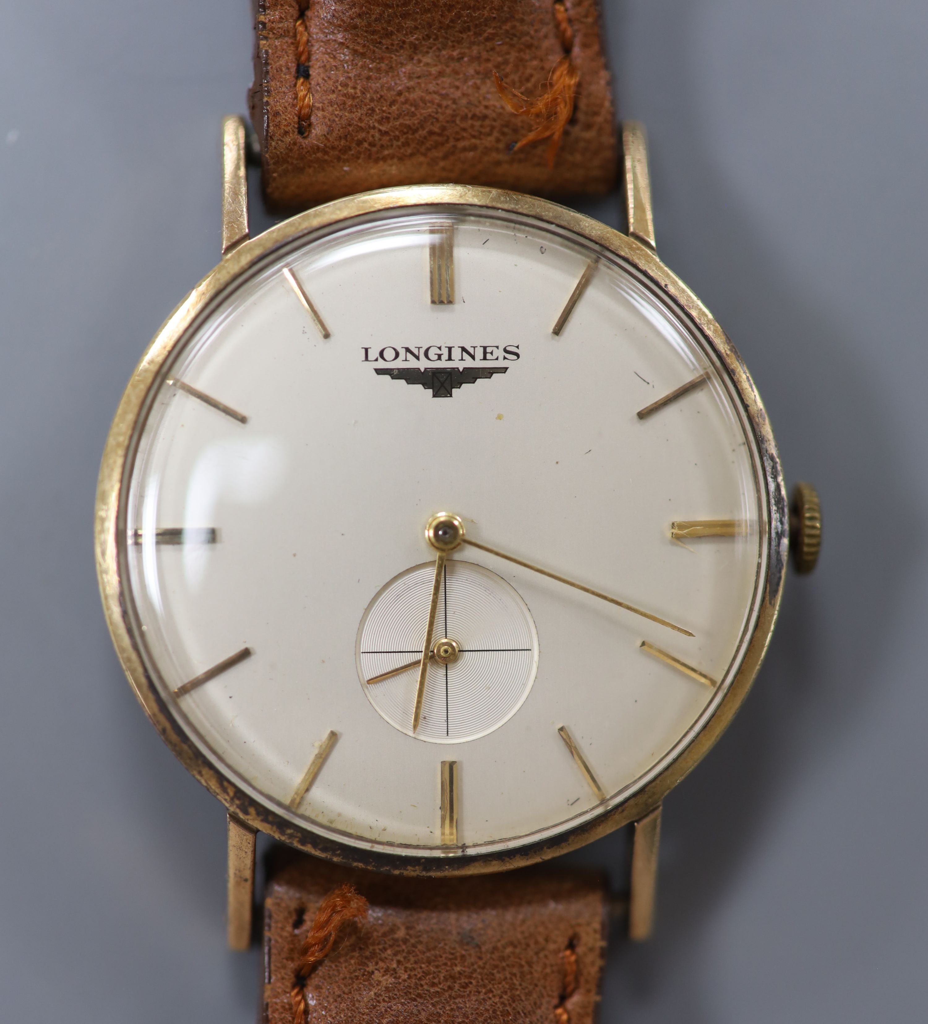 A gentleman's late 1950's 9ct gold Longines manual wind wrist watch, on a leather strap, case diameter 31mm, gross 27.2 grams.